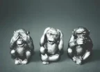Black and white photo of three wise monkeys figurines showing the hear no evil, see no evil, speak no evil poses.